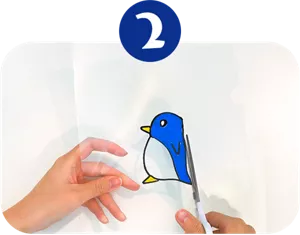 ②クリアファイルに描かれたペンギンをはさみでカットしている画像