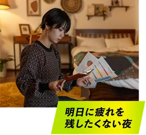明日に疲れを残したくない夜。自宅で明日のプレゼン資料のチェックをしている女性イメージ