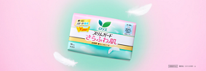 ロリエの生理用ナプキン、スリムガードさらふわ肌の商品ビジュアル。淡いピンクと緑色の空間、羽とともに商品が置かれている。。