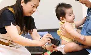 赤ちゃんの肌を実際に器機で測定する研究員の画像