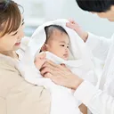 ママとパパに体を拭いてもらっている赤ちゃん