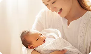 新生児を抱っこするママ