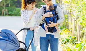 赤ちゃんを抱っこしてお散歩する家族