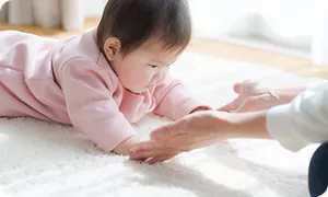 うつぶせ姿勢でママと遊ぶ赤ちゃん