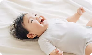 ベッドの上で足をバタバタする赤ちゃん