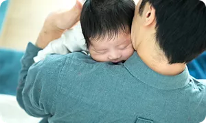 赤ちゃんにげっぷをさせるパパ