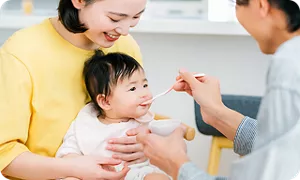 赤ちゃんに離乳食を食べさせるパパ