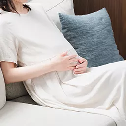 おなかに手を当てる妊婦