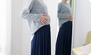 体形をチェックする妊婦