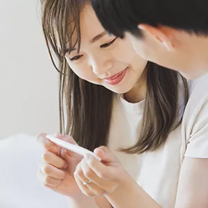 妊娠検査薬の結果を見る夫婦