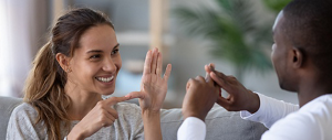 A young woman and man speaking in sign language.