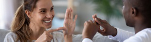 A young woman and man speaking in sign language.