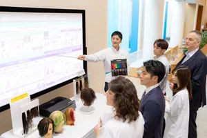 Researchers from Japan and overseas discussing research results and technologies and sharing knowledge at a Kao R&D site.