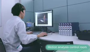 This photograph shows a man during work in a motion analysis device control room looking at a monitor.