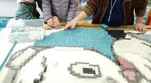 A photo of children making a relief of　the official character of Onagawa Town, using Okaeri-blocks.