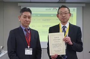 Photo taken at the awards ceremony with the certificate of recognition.