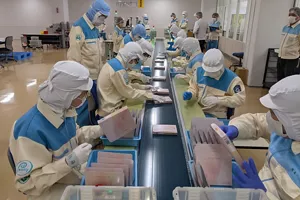 Employees in the Production Division are working on setting up products by "flow work method" using a conveyor belt.