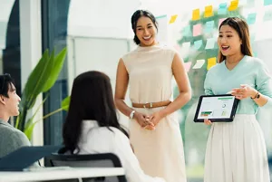 兩名員工使用平板電腦向另外兩名同事進行匯報。