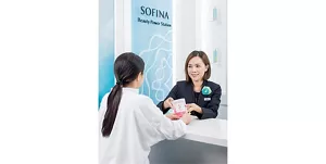 一名Sofina美容顧問正在向顧客派發“關愛自己及所愛之人”的宣傳手冊。