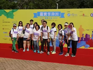 一群參加者在「靈實耆趣跑2015」活動背景板前合照。