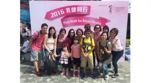 一群花王香港員工和其親友在「乳健同行2016」活動背景板前合照。