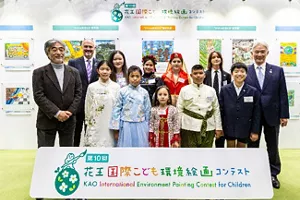 第10屆比賽的得獎者和評委站在花王國際兒童環境繪畫比賽的橫額後面合照。他們身後展示了各個參賽作品。