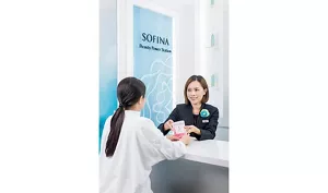 一名Sofina美容顧問正在向顧客派發“關愛自己及所愛之人”的宣傳手冊。