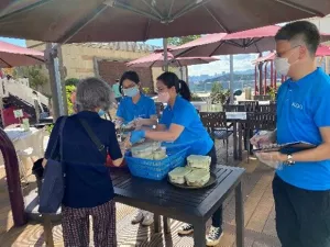 義工們將飯盒派發給一位老人。