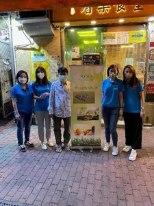 4名義工與活動協辦人在餐廳門口合照。