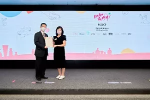 花王香港代表從主辦單位手上接過約章宣言，背後的大螢幕展示了「Bye Bye微膠珠」和花王公司標誌。