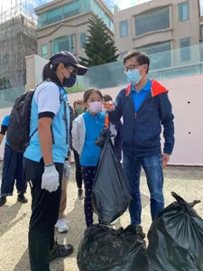 一名花王香港員工使用手提電子秤測量垃圾袋的重量，並向工作人員展示結果。