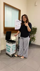 A female Kao Indonesia employee throws away calendar trash in the Bring Back to Care and Donate campaign