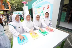 photo of students putting their hands in ink as a joint commitment of Kao Indonesia and Al-Kenaniyah