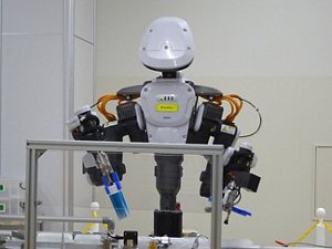 写真2　品種やロットの有無を確認しながら包装容器を供給する作業を行なうヒト型協働ロボット