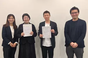 贈呈式の会場で、助成先の代表の皆さまが助成決定通知書を手に事務局のメンバーと記念撮影をしている様子