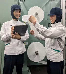 シート型製品の加工機前で作業をする研究員２名