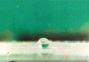 最初に撮影されたフラクタル表面上の水滴の写真。水滴は弾かれて、球のような形になっている。