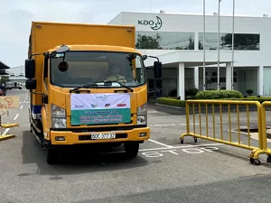 Một chiếc xe tải màu vàng chạy ra khỏi khu đất của Kao Việt Nam.