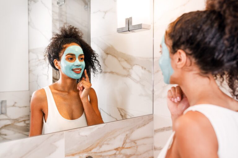 Girl with a face mask in the mirror treating blackheads