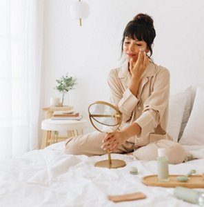 Woman applying a noursihing cream as part of her winter skincare routine