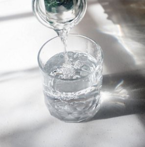 Filling a glass with water from a glass decanter