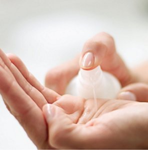 Woman applying a gel-like hydrating essence to the palm of her hand