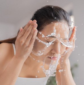 Woman splashing water on her face