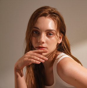 Young redheaded woman with clear, glass-like skin
