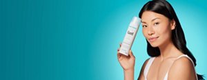 Young woman holding a can of Curél Deep Moisture Spray