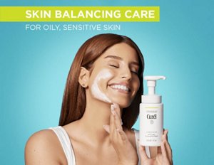 Woman using Curél Oil Control Foaming Facial Wash against a teal background