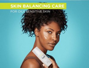 Woman holding a bottle of Oil Control Weightless Gel Moisturiser against a teal background