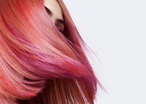 Une femme dont le visage est couvert d’une chevelure rousse et fluide