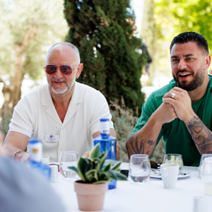four diverse woman with different hair colors and lenghts, which stand side by side and close to each other looking into the camera while standing in front of a clean grey background