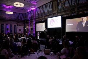 four diverse woman with different hair colors and lenghts, which stand side by side and close to each other looking into the camera while standing in front of a clean grey background
